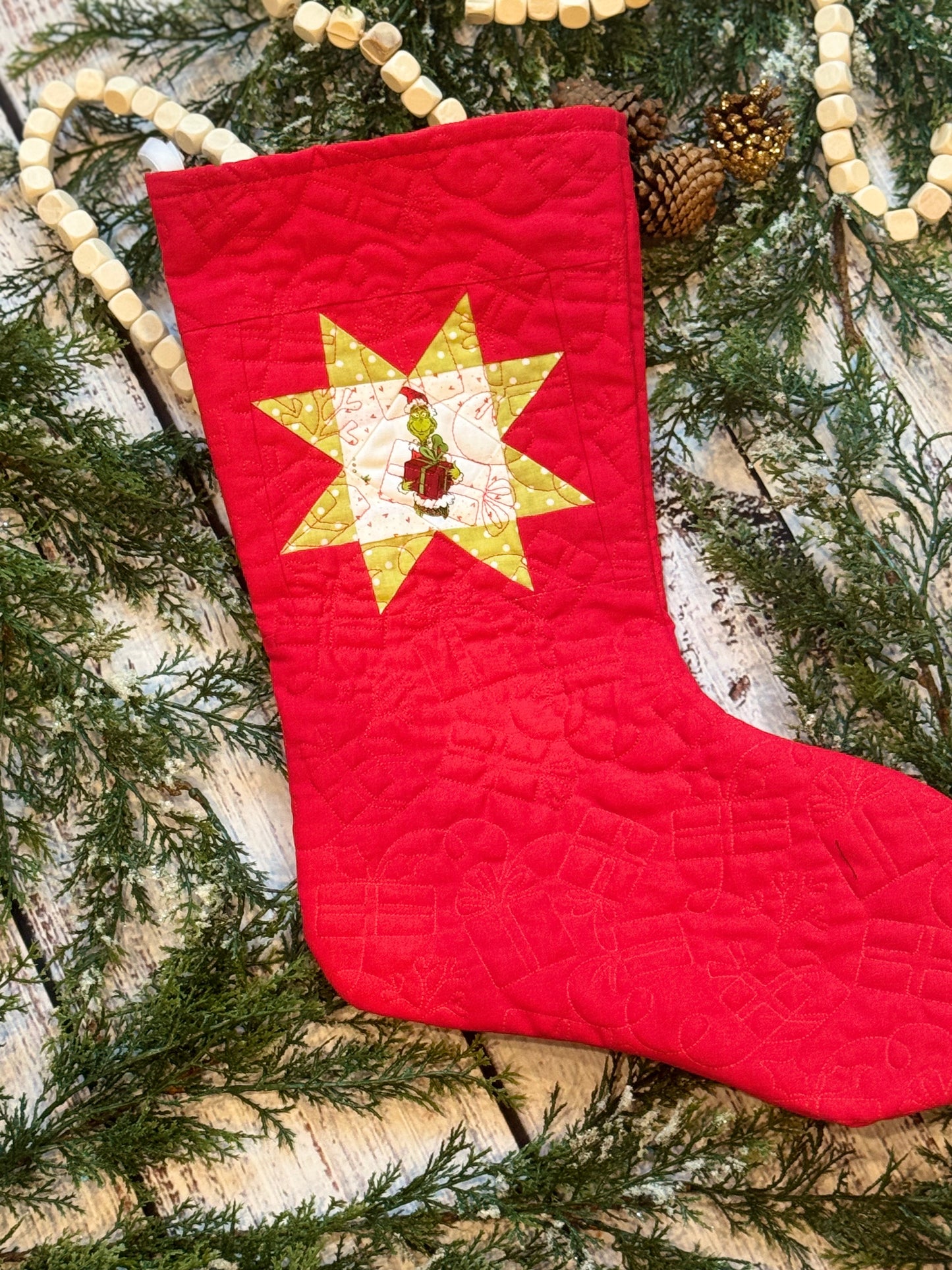 The Grinch Stocking holding red present on Christmas Red